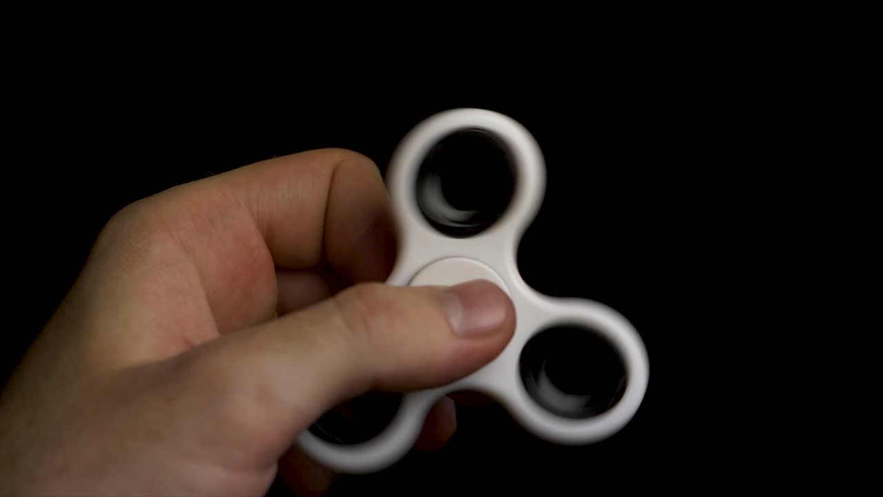 Person spinning a white fidget spinner