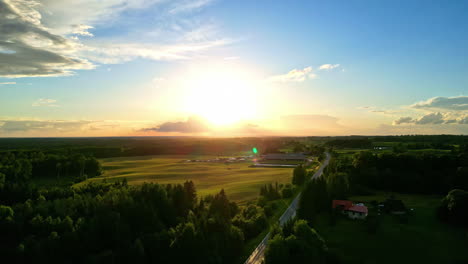 Landscape-pan-of-beautiful-early-morning-sunrise-on-horizon-with-rays-bursting-through-clouds-in-sky-scenery-nature-outdoors-countryside-farm-acreage-rural-town