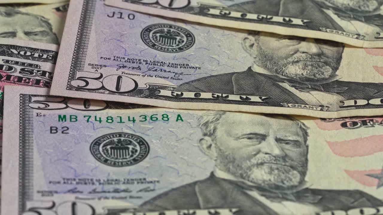 Close up of folded fifty dollar bills on a surface