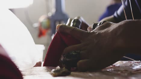 close up view of man stitching in factory