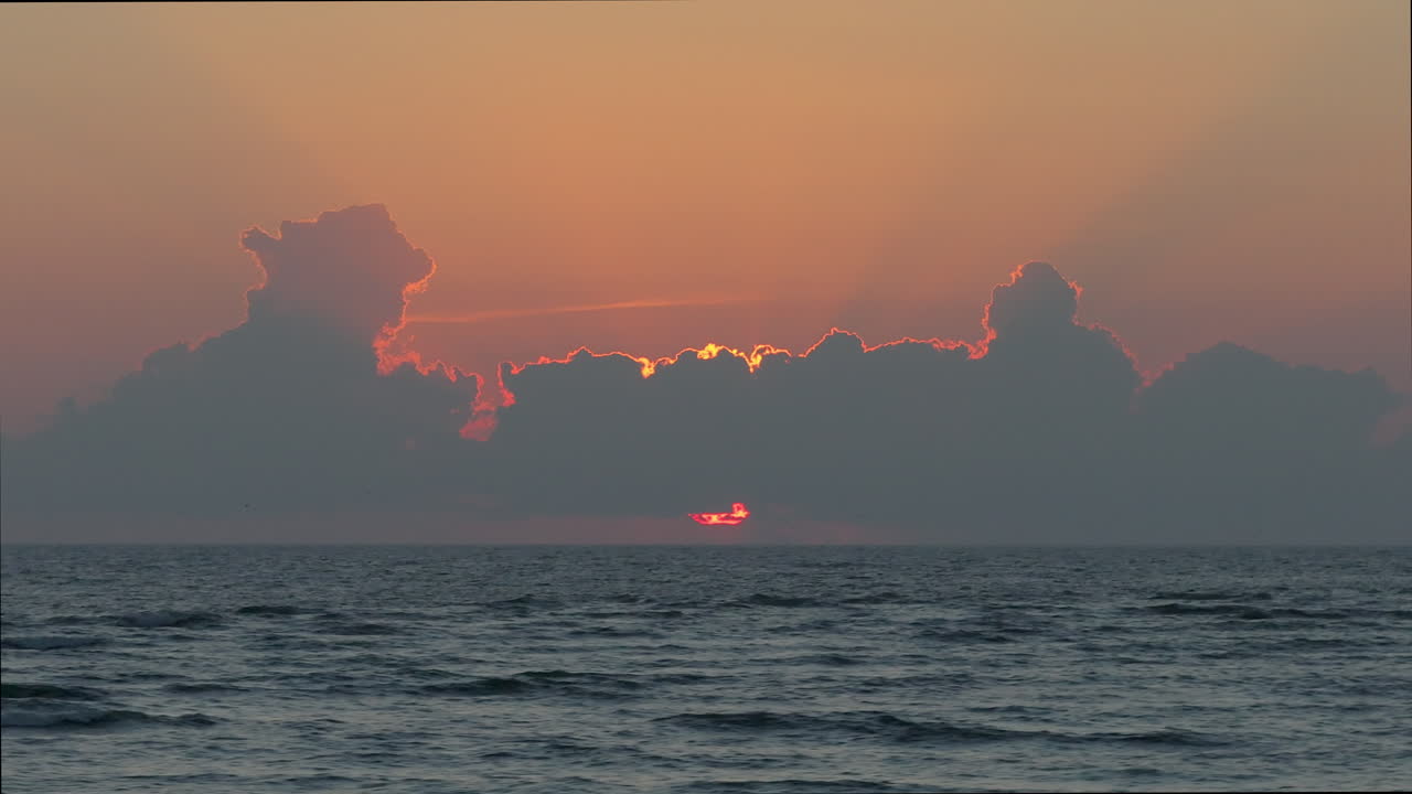 구름과 함께 바다 위에 해가 지는 것