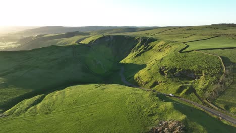 aerial push in tilt down over the winnats pass in the peak district, uk to reveal the gorge and road