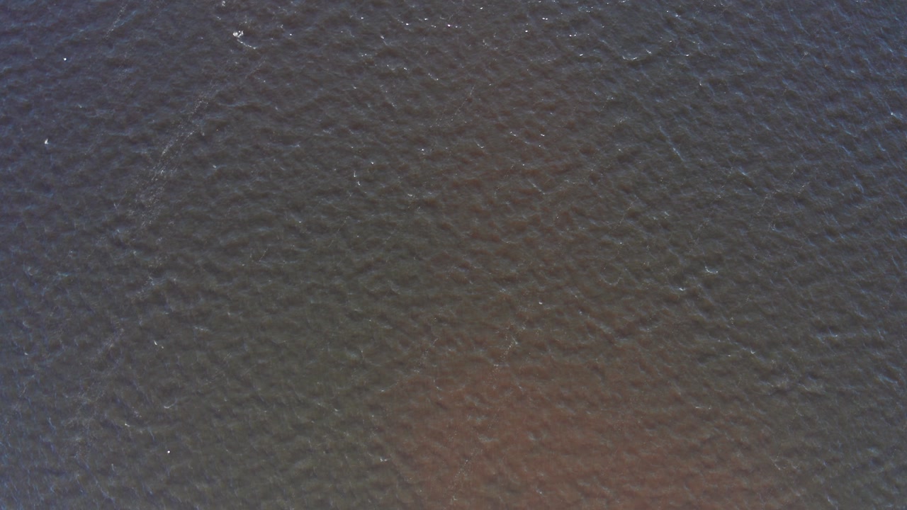 Gentle ripples create a textured pattern on the water's surface, offering a serene and abstract visual. Ideal for backgrounds or nature-themed projects.
