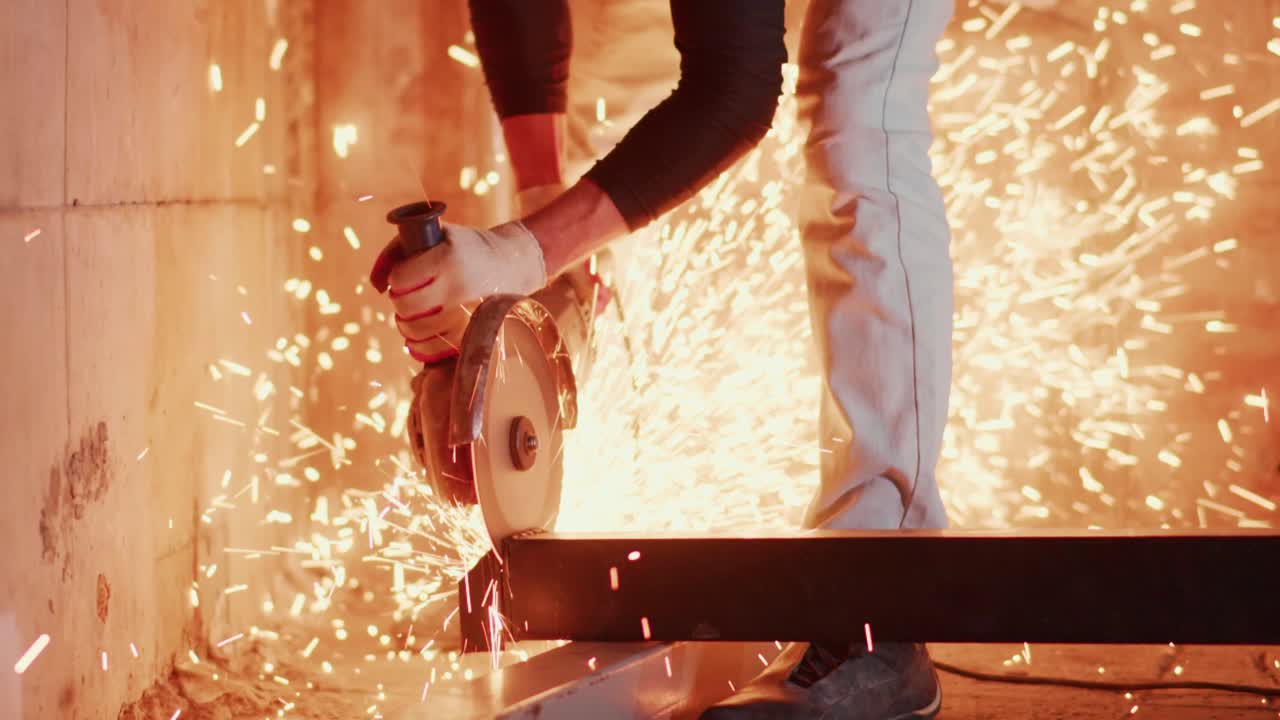 Lavoratore che taglia trave metallica con smerigliatrice angolare, producendo scintille intense.