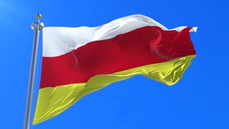 flag of north ossetia waving at wind in slow in blue sky, loop