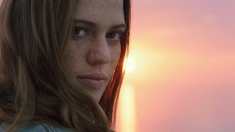 retrato de cerca de una hermosa mujer joven que se ve confiada disfrutando de la playa al atardecer