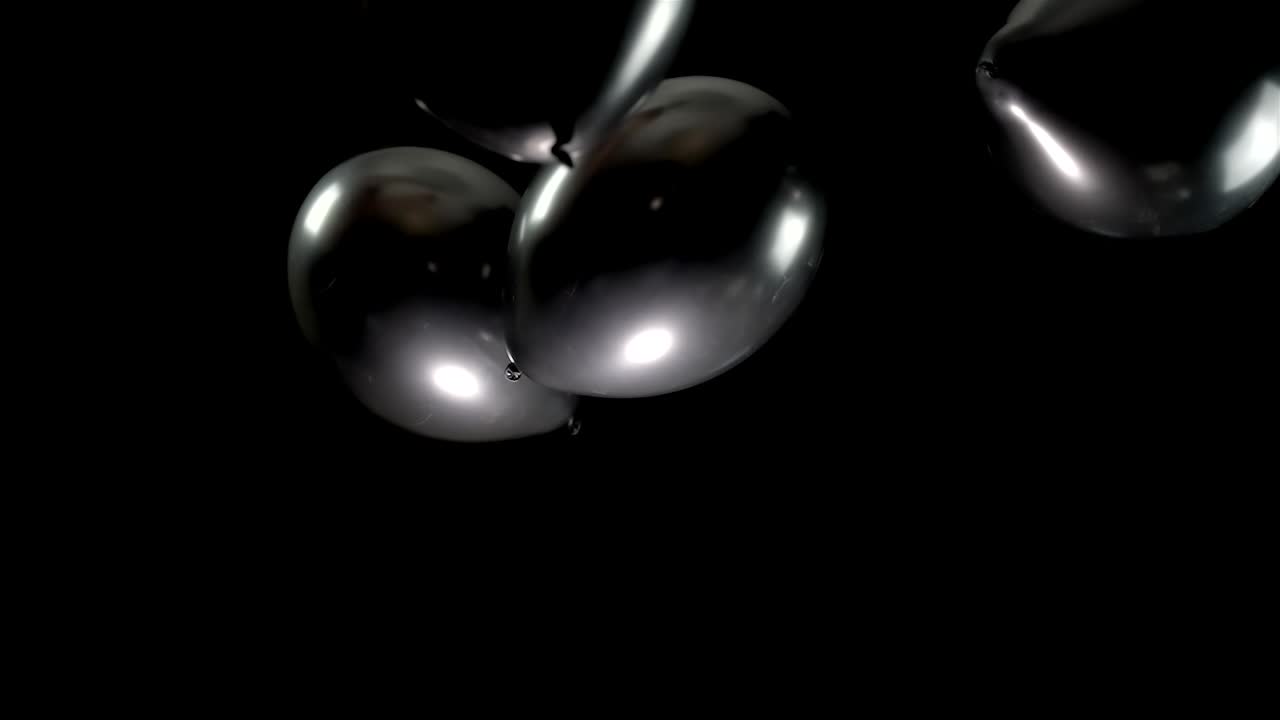 Experience the elegance of black balloons floating in slow motion. Their graceful movement creates a dramatic atmosphere, perfect for adding a touch of sophistication and mystery to any project.