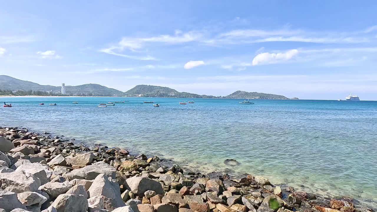 A tranquil 20-second video capturing the rocky shoreline and clear waters of Kalim Beach under bright daylight