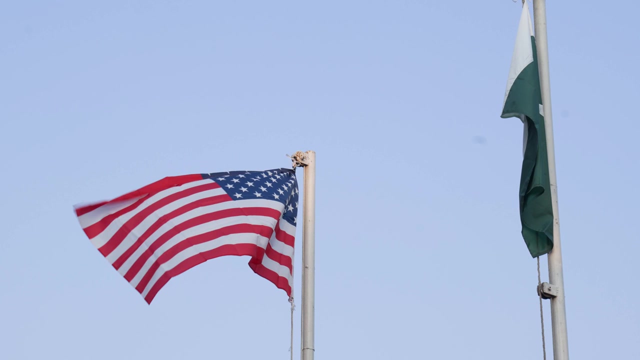 United States Of America And Pakistan Flags United And Waving In The Wind Together.