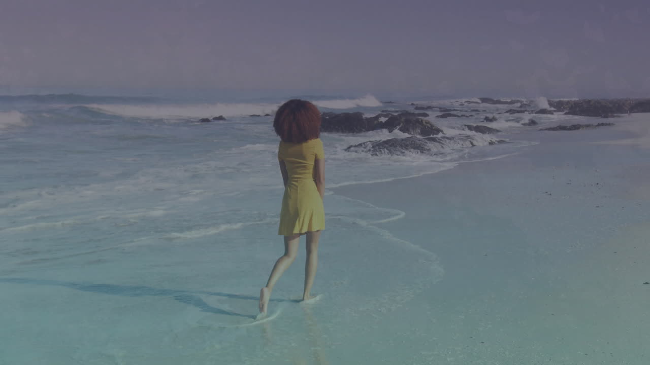 Walking on beach, woman in yellow dress over ocean waves animation
