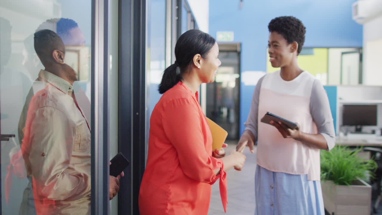 African american business people shaking hands at office, slow motion