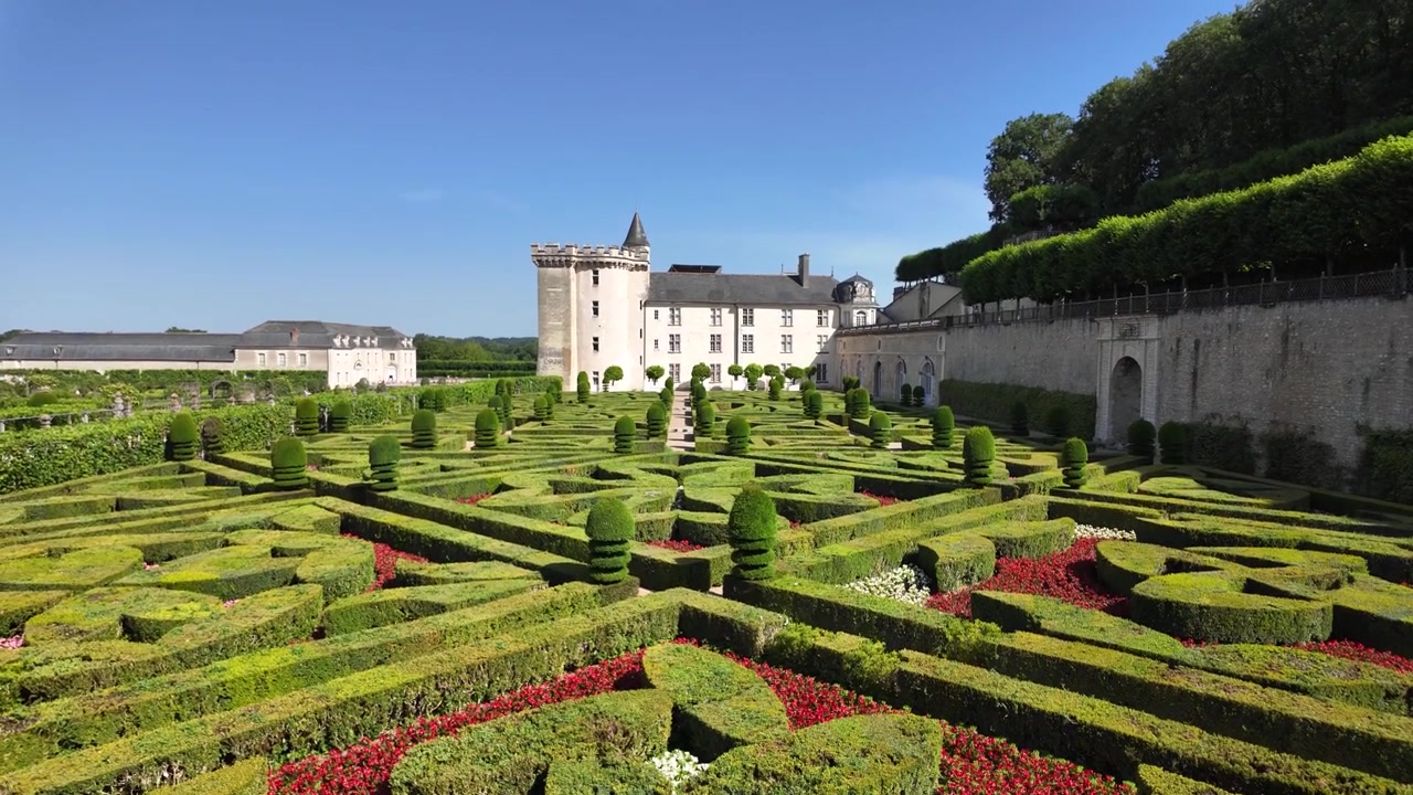 Vista al rallentatore attraverso i giardini rinascimentali del Castello di Villandry, che evidenzia intricati disegni di parterre, siepi curate e lo storico castello nella Valle della Loira, Francia