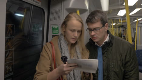 pareja adulta con un mapa en el tren del metro