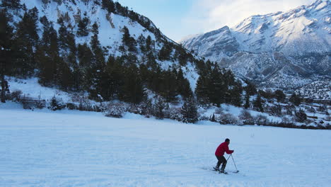 Skiing-wonderfully,-Nepal-land-of-Wonderland-Annapurna-circuit-region,-Drone-shot-of-snowy-landscape-with-a-trekker-enjoying-adventure-4K