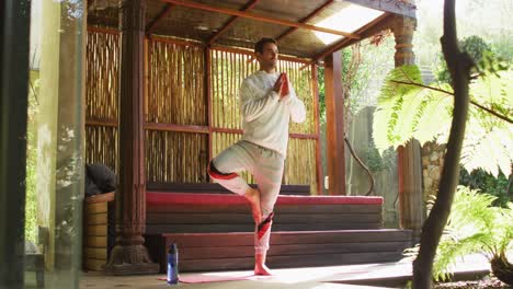 caucasian man practicing yoga and meditating at vacation home