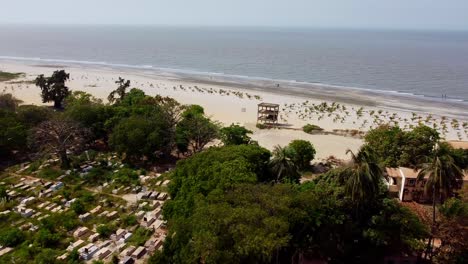 panning establishment panorama shot with drone of christian cemetary in the wonderful capital banjul city in gambia with a view of the blue sea and landscape with trees and beautiful beach