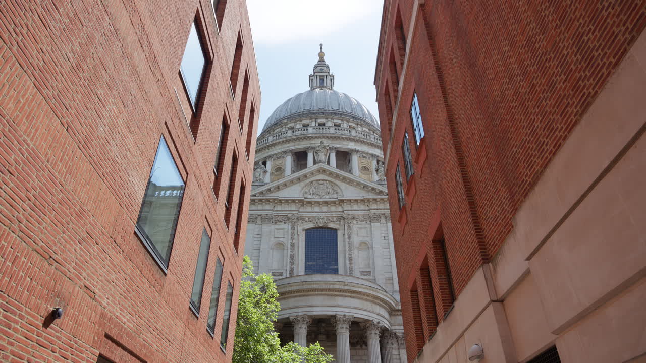 Framed view of St. Paul's Cathedral dome between two modern brick buildings in London, England