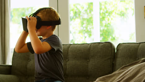 chico usando auriculares de realidad virtual en el sofá 4k