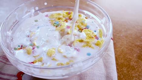 flocos de maíz amarillos crujientes en el cuenco para la mañana un delicioso desayuno con leche. cámara lenta con toma de seguimiento de rotación.