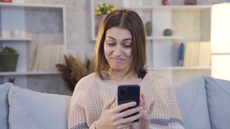 Young-Woman-Using-Smartphone-Smiling-And-Enjoying-Comfort-At-Home.