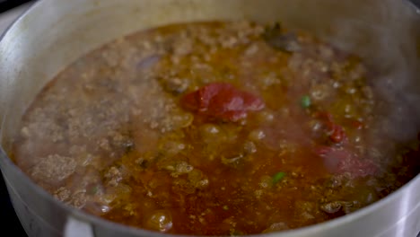 sizzling curry sauce with chopped beef with steam vapour rising. slow motion shot