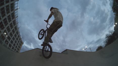 Ciclista-De-BMX-Sacando-Aire-Enorme-Del-Tazón-Del-Skatepark-Al-Amanecer,-Seguimiento-De-Ojo-De-Pez-A-Cámara-Lenta-Extrema-De-800-Fps