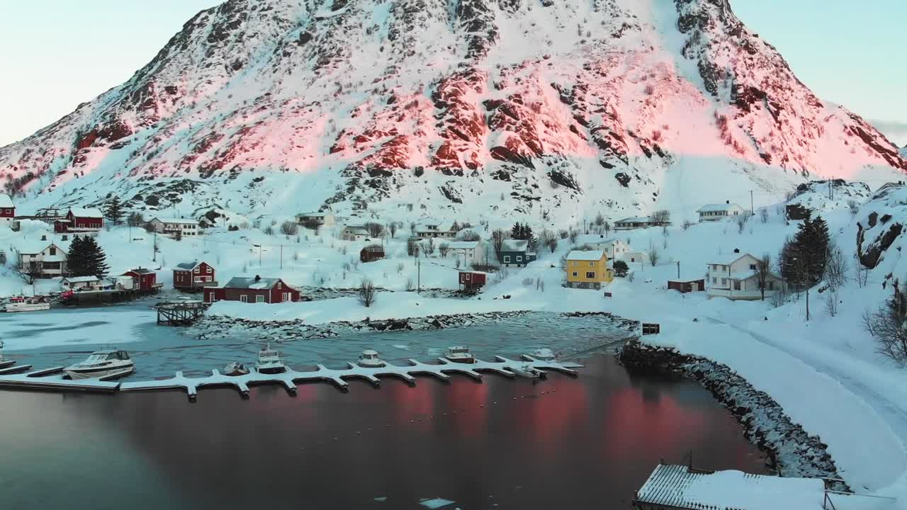 노르웨이 로포텐 섬의 산에서 일출이 있는 작은 마을의 항구와 일부 보트