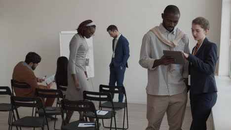diverse colleagues using tablet and talking
