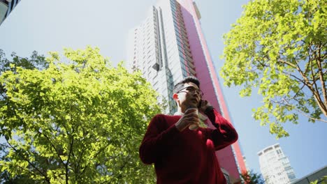 man with coffee cup talking on mobile phone on street 4k