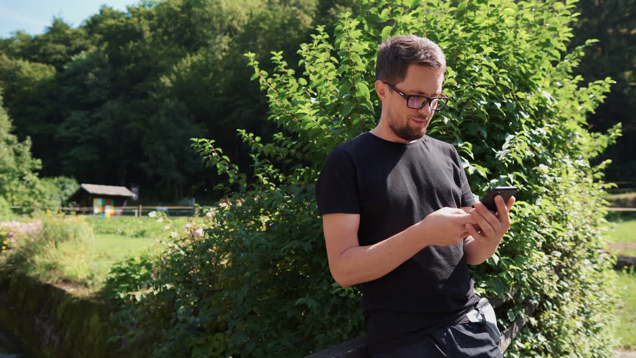 hombre usando un teléfono inteligente al aire libre en un jardín