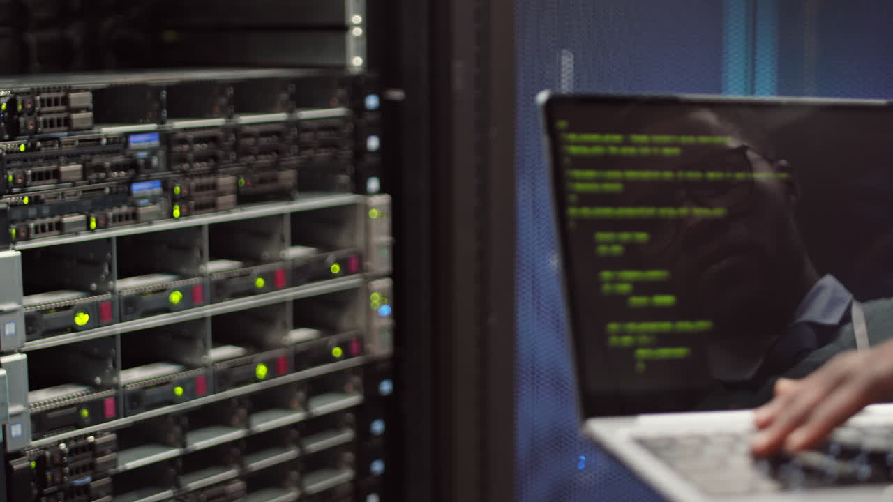 IT Specialist Coding on Laptop in Server Room