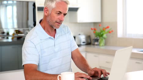 Casual-man-using-laptop-at-the-counter