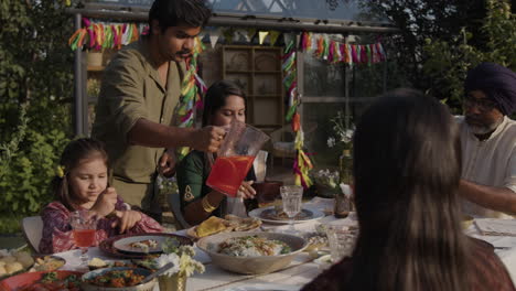 south asian family enjoying an outdoor festive meal in a garden