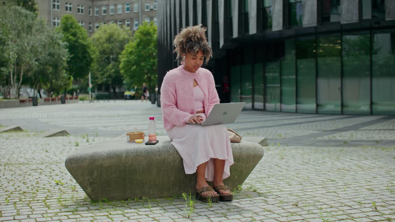 Woman working on laptop outdoors