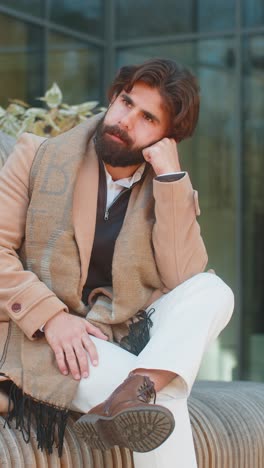sad unhappy frustrated indian man sitting alone in city street feeling bad annoyed grief problem