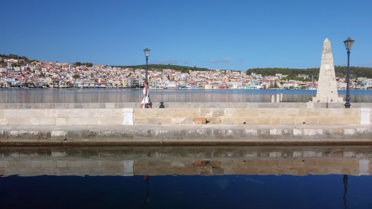 Woman walking by the most famous obelisk, monument in Argostoli city, capital of Kefalonia, Greece