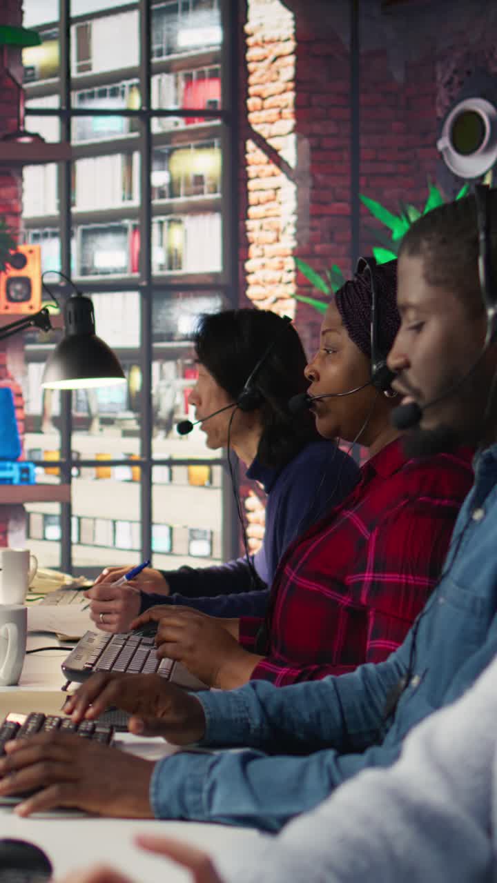 Vertical video Call center employees wearing headset assisting customers in office, close up