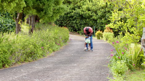 african american, father hugging child on garden path, sharing tender moment outdoors, copy space