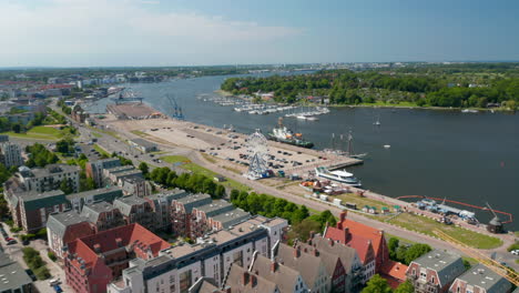 Aerial-view-of-coastal-urban-district-with-various-colourful-houses-and-large-parking-lot-with-Ferris-wheel-attraction-on-waterfront