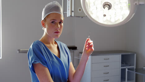 portrait of nurse holding surgical tool