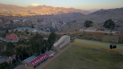 aerial view flying over cable cars and a football field in la paz, bolivia