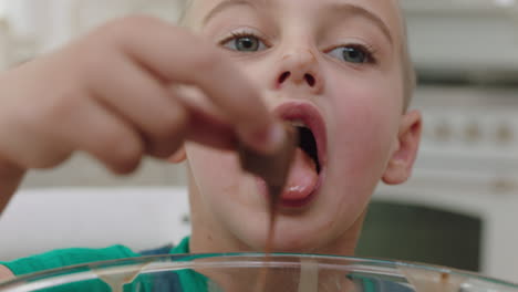 happy little boy tasting delicious chocolate treats in kitchen enjoying homemade sweets having fun on weekend