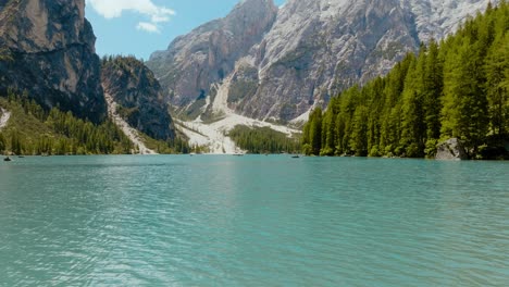 toma aérea de un dron sobre el río y el bosque con los alpes dolomitas en la parte de atrás, lago di braies, italia, dolomitas