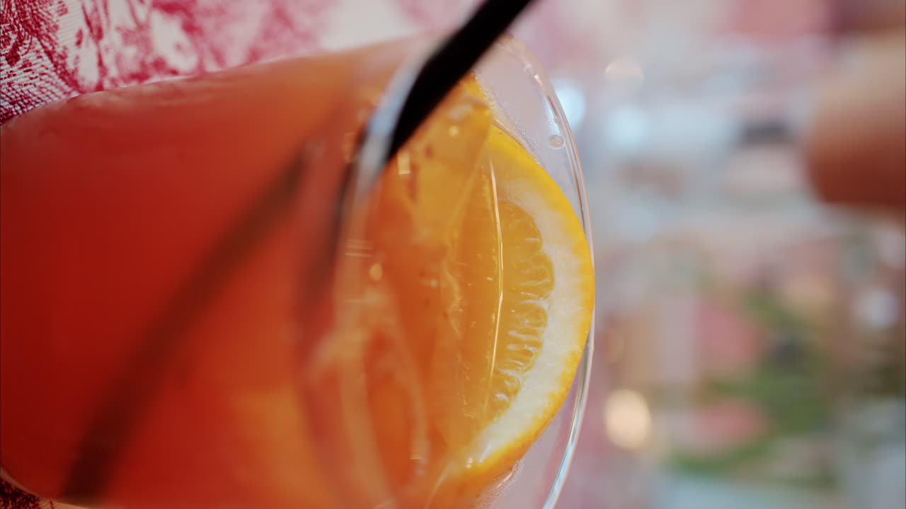 Primo piano di un cocktail arancione su un tavolo in un ristorante. Verticale