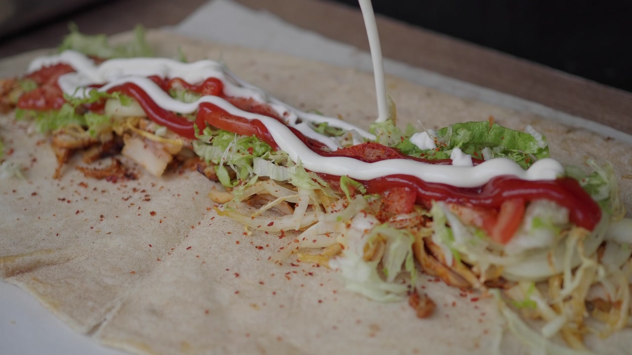 Adding Ketchup and Mayonnaise to a Fresh Doner Kebab Wrap