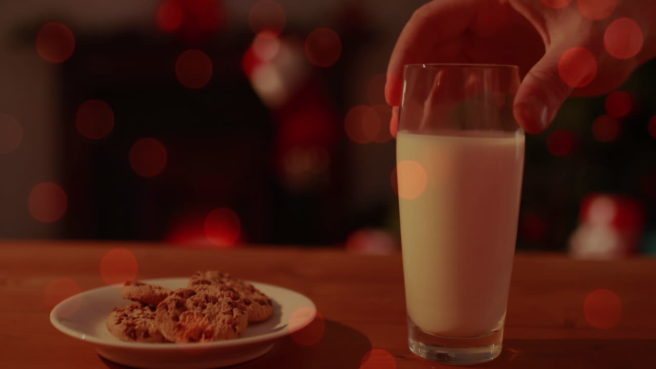 Animazione di un bicchiere di latte e un piatto di biscotti con lucine.
