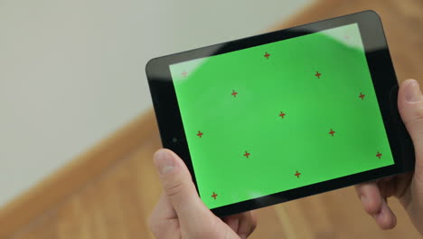 hombre sosteniendo una tableta con pantalla verde. hombre leyendo un libro electrónico con pantalla verde