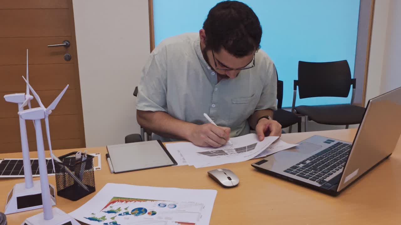 Ingeniero haciendo anotaciones en un plano de un sistema de paneles solares