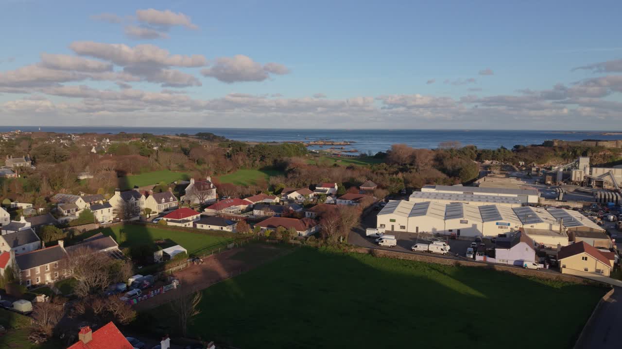 Volo su St Sampson Guernsey con panoramica sulla zona industriale fino al Castello di Vale, con il Canale di Little Russell e Herm in lontananza in una giornata di sole splendente