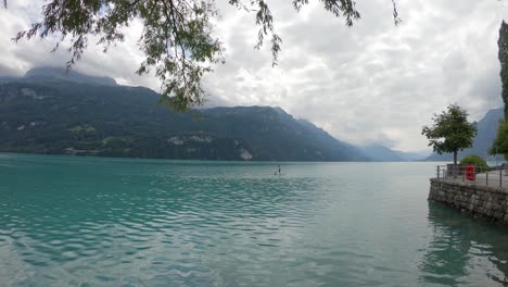 persona irreconocible remando a bordo de sup en el sereno lago brienz, suiza